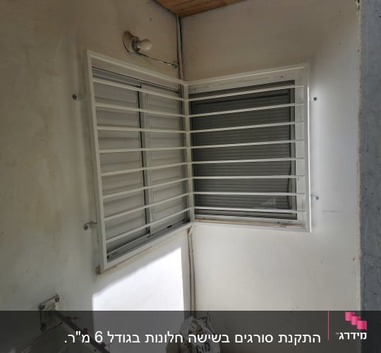 סורגים לבנים על חלון בפינת קיר